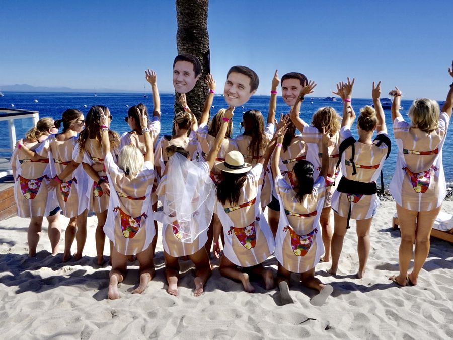 A bachelorette party celebrating together on a white-sand beach